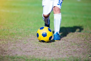 Çocuk futbol oyuncu hız çalıştırmak hedefe yeşil çimenlerin üzerinde topa vurmaya. Futbol oyuncu eğitim veya futbol maç.