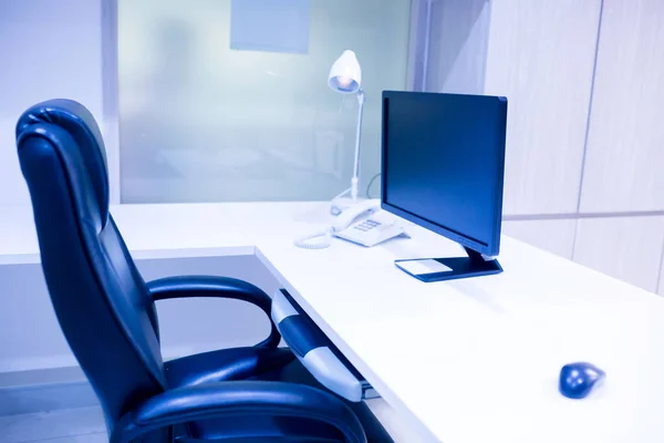 コンピューターは 明るいインテリアのテーブルの上です 白いマネージャー デスクと とマウスのオフィスで黒の回転椅子 — ストック写真