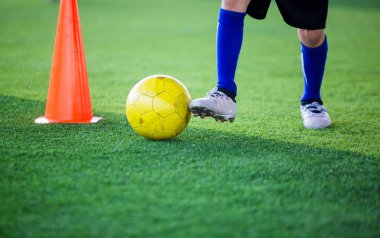 Çocuk futbol oyuncu kontrol top koni maker yeşil suni çim futbol eğitim için