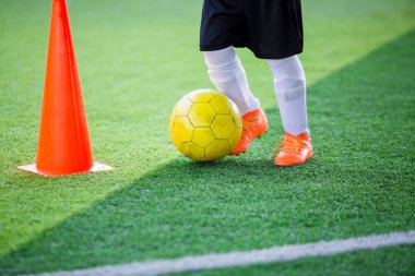 Çocuk futbol oyuncu kontrol top koni maker yeşil suni çim futbol eğitim için