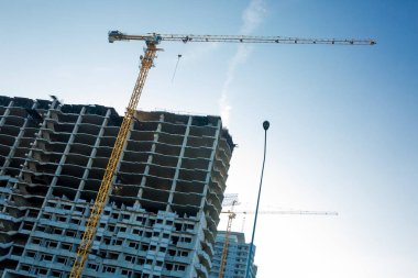 Bina vinç ve binaların yapım aşamasında. İnşaat vinç ve mavi gökyüzü karşı bina
