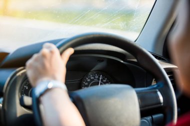 Adam sabahın köründe seçici bir dikkatle araba sürüyor.