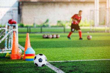 Futbol ve futbol antrenmanı ekipmanı ile yeşil yapay çim futbol oyuncular eğitim bulanık. Futbol Akademisi.