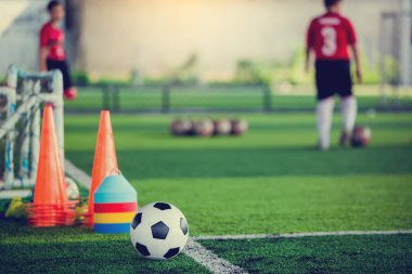 Futbol topu ve futbol antrenmanı ekipmanı ile yeşil yapay çim futbol oyuncular eğitim bulanık. Futbol Akademisi.