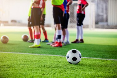 Eğitim ve başlangıç oyun önce ayakta bulanık futbolcular ile yeşil yapay çim futbol topu.