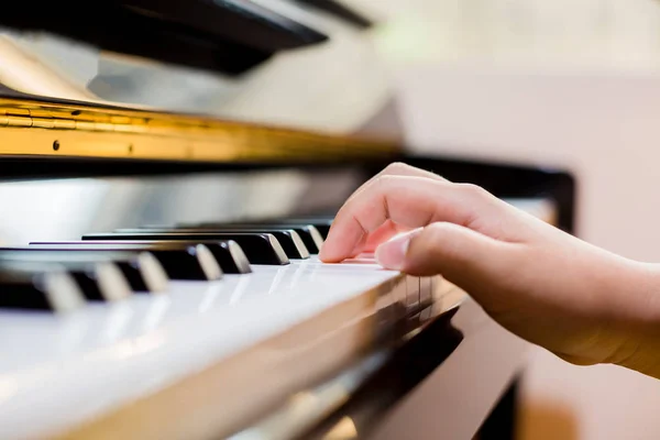 Selective focus of kid fingers and  piano key to play the piano with lighting. There are musical instrument for concert or learning music.