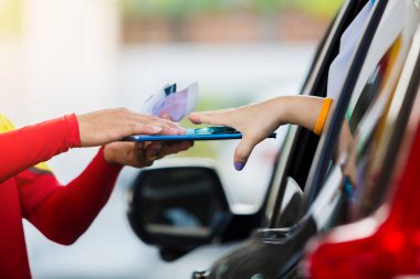 Kadını sürücüsü için seçici odak için yakıt benzin istasyonunda personel kredi kartıyla ödeme.
