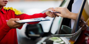 Kadını sürücüsü için seçici odak için yakıt benzin istasyonunda personel kredi kartıyla ödeme.