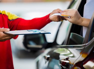 Kadını sürücüsü için seçici odak için yakıt benzin istasyonunda personel kredi kartıyla ödeme.