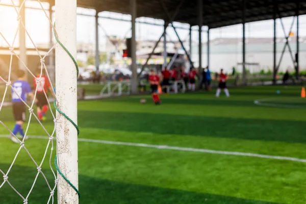 Beyaz goalposts ve bulanık futbolcuların gol örgü. Futbol Akademisi.