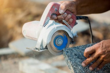 işçi kesim granit taş bir elmas elektrikli testere ve toz ve ısı bir inşaat sahasında önlemek için su kullanımı 