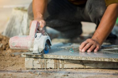 işçi kesim granit taş bir elmas elektrikli testere ve toz ve ısı bir inşaat sahasında önlemek için su kullanımı 