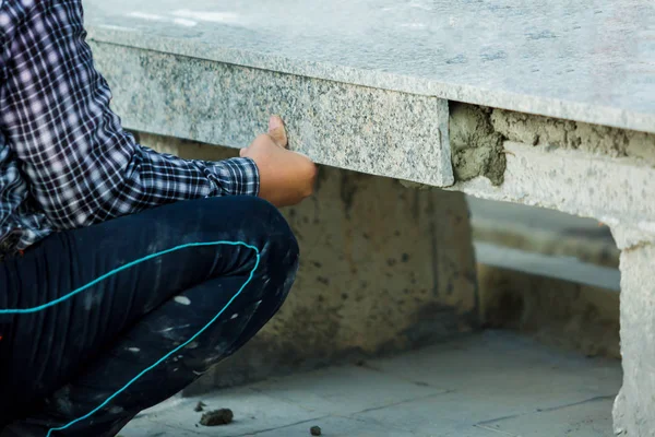 house improvement, renovation, construction industry worker installing granite stone tiles with cement on architectural house