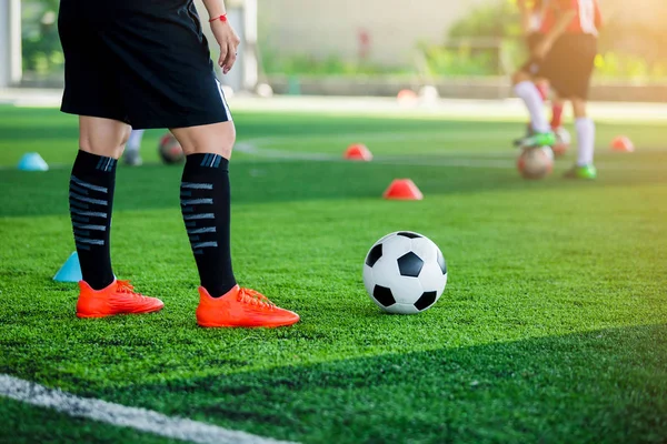 Entrenador de jugador de fútbol de pie y pisando la pelota —  Fotos de Stock