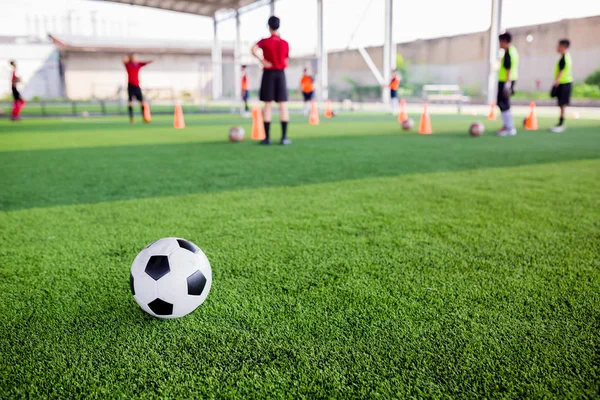 Fútbol en césped artificial verde con jugadores de fútbol borroso —  Fotos de Stock