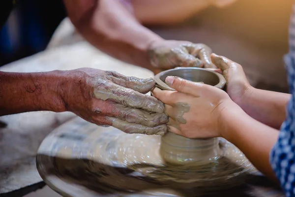 Närbild på händerna på potter lärare och barn — Stockfoto