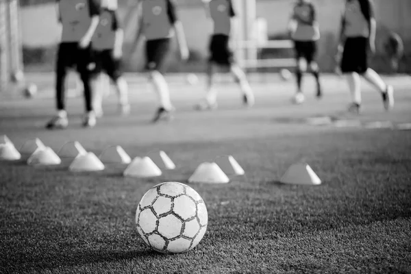 Futbol topu ile yeşil yapay çim makinesi koniler, bulanık 