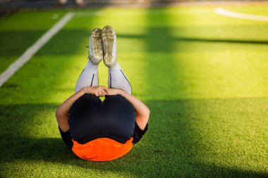 Çocuk futbolcu geri yalan ile kasları germek 