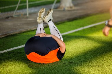 Çocuk futbolcu geri yalan ile kasları germek 