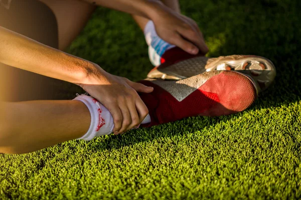 Footballers are sitting and catch the soles of the feet because — Stock Photo, Image