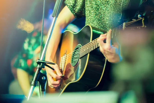 musician\'s hands playing guitar at a live show on stage