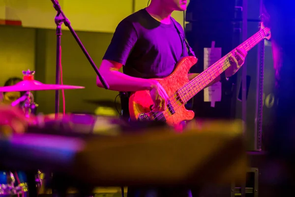 musician\'s hands playing guitar bass at a live show on stage