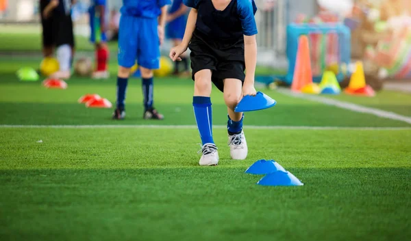Foco seletivo para criança jogador de futebol marca marcador cone azul — Fotografia de Stock