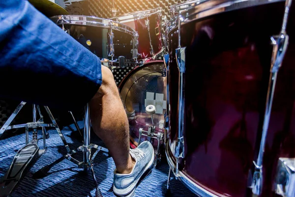 Man put white sport shoes and playing the drum set and bass drum — стоковое фото