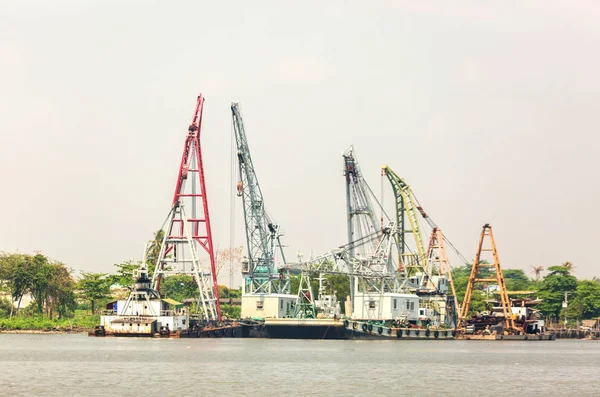 towing boat or cargo ship with crane at riverside port