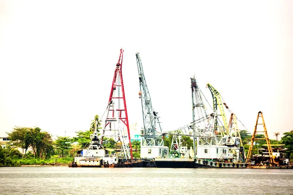 towing boat or cargo ship with crane at riverside port
