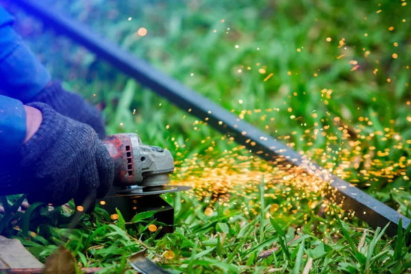 Die Hände der Arbeiter schleifen oder schneiden Metall mit dem Schleifer bei outdoo — Stockfoto