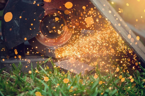 Arbeiter beim Schneiden von Metall mit dem Schleifer auf Rasen im Freien oder constructio — Stockfoto