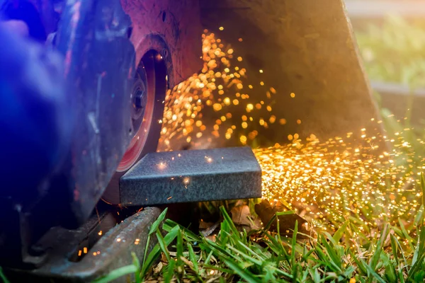 Arbeiter beim Schneiden von Metall mit dem Schleifer auf Rasen im Freien oder constructio — Stockfoto