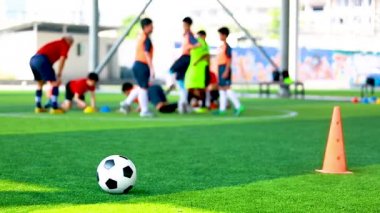 Futbol topu ve koni marker ile yeşil suni çim üzerinde bulanık eğitim futbolcu. Futbol Akademisi