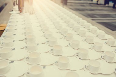 Beyaz masada bir sürü beyaz kahve bardağı