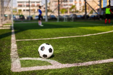 futbol sahası köşesinde yeşil suni çim üzerinde futbol topu