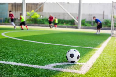 futbol sahası köşesinde yeşil suni çim üzerinde futbol topu
