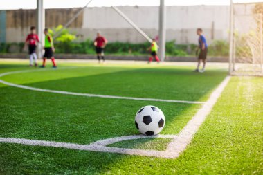 futbol sahası köşesinde yeşil suni çim üzerinde futbol topu