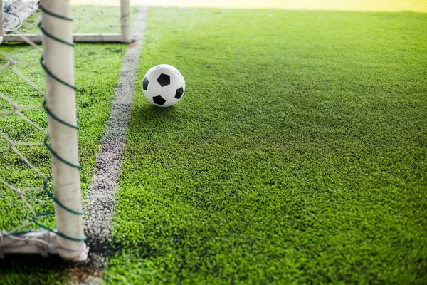 Расплывчатый футбольный мяч на зеленой искусственной территории двигаться к воротам на фронте — стоковое фото