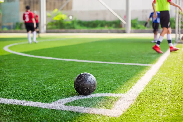 soccer ball on green artificial turf at corner of football field