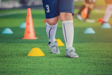 çocuk futbolcu Jogging ve koni işaretleri arasında atlamak