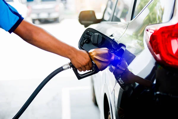 Manos llenando el coche con combustible en la gasolinera, coche negro — Foto de Stock