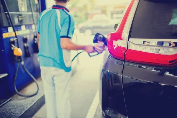 Розмиті руки, що поповнюють автомобіль панеллю управління паливом і пресом — стокове фото