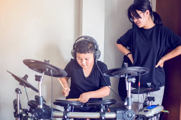 Aziatische meisje en jongen zetten zwarte tshirt en hoofdtelefoon leren en p — Stockfoto