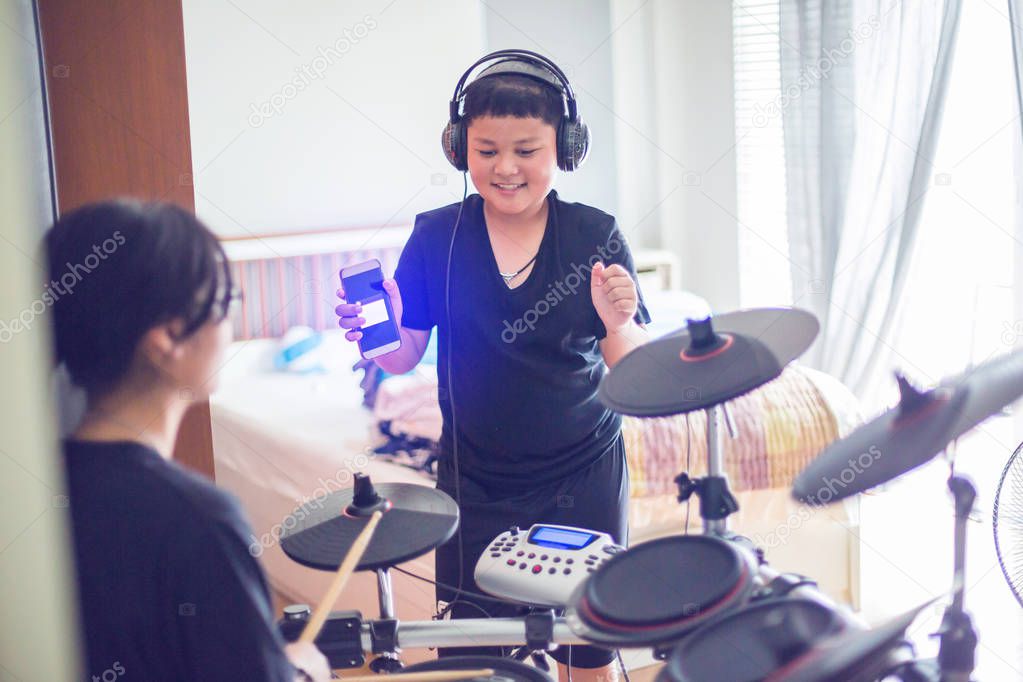 Asian girl and boy put black tshirt and headphone learning and p