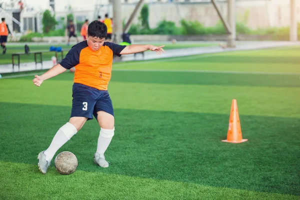 Soccer player speed run to shoot ball to goal on artificial turf