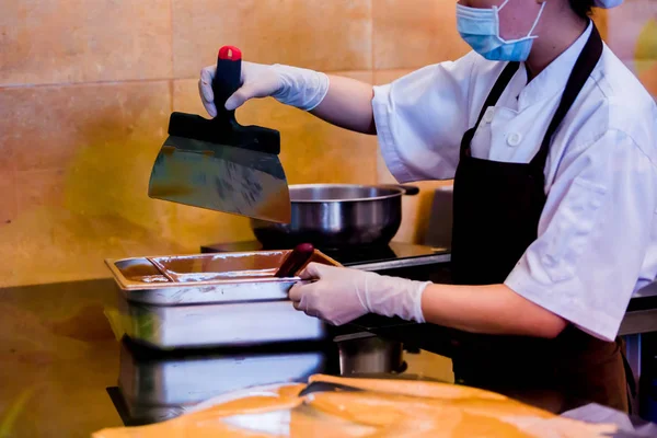 Cocinera está mezclando crema de chocolate con espátula profesional i — Foto de Stock