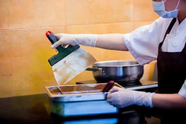 cook woman is mixing chocolate cream with professional spatula i