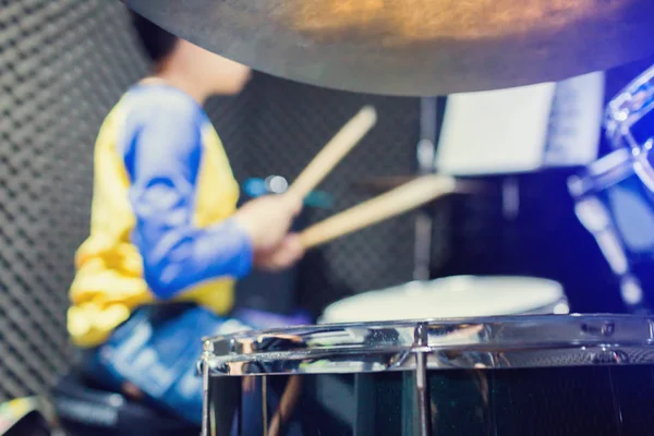 Wooden drumsticks in hands of Asian kid wearing blue and yellow — 스톡 사진