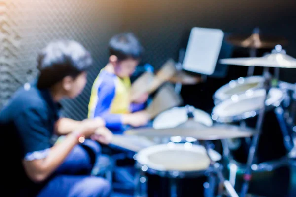 Руки учителя с деревянными барабанными палочками направляющего мальчика в барабане Лира — стоковое фото